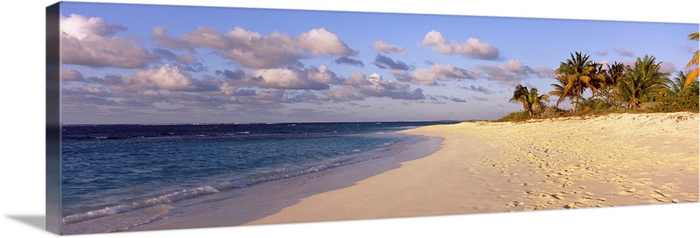 Big panoramic photo of waves trickling onto the Shoal Bay Beach in Anguilla. Fooprints can be seen in the sand on the beac...