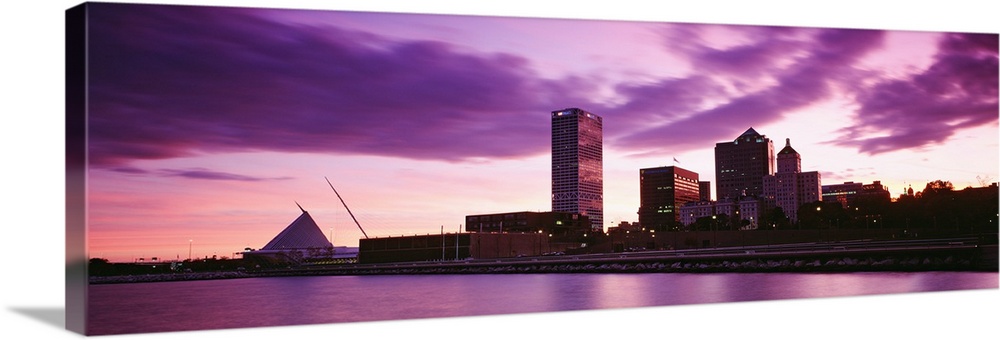 Taken from on the water at sunset this panoramic photograph shows city skyscrapers built along the waterfront.