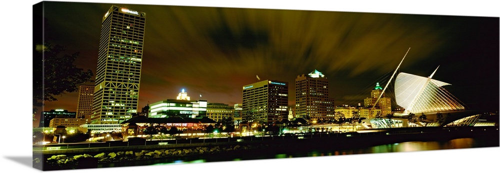 Wide angle photograph from water level of skyline lit up on panoramic wall art.