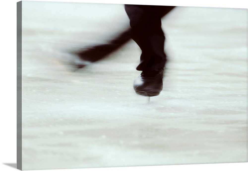 Detail of male figure skater's legs and boots spinning.