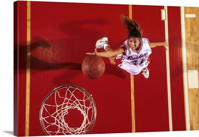 Female basketball player going up for a shot