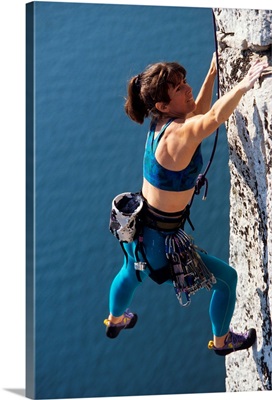 Female rock climber reaching for a grip