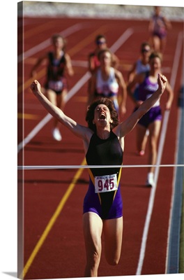 Female runner victorious at the finish line in a track race