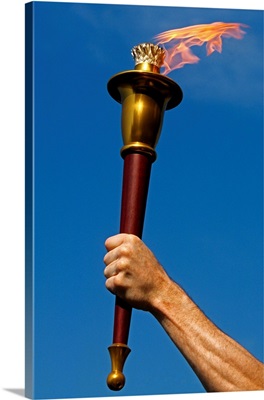 Photograph of mans hand holding ceremonial torch