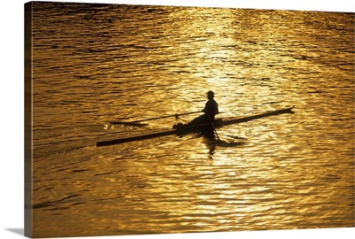 Rower silhouetted on a lake