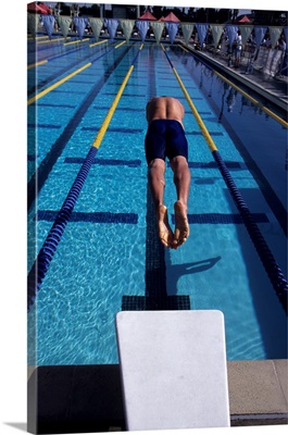 Swimmer diving off the starting blocks to begin a race