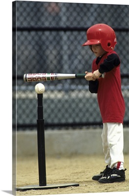 Young boy batting during a tee ball game