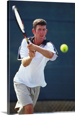 Young male tennis player in action