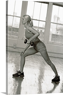 Young woman working out with hand weights