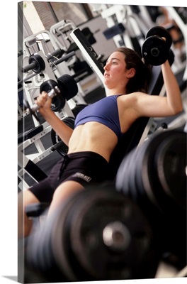 Young woman working out with hand weights