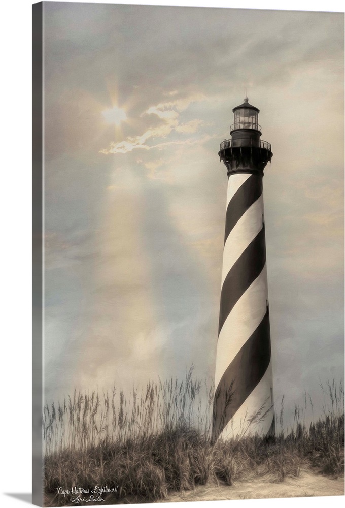 Black and white striped Cape Hatteras lighthouse on the Outer Banks with the sun shining through the overcast sky.