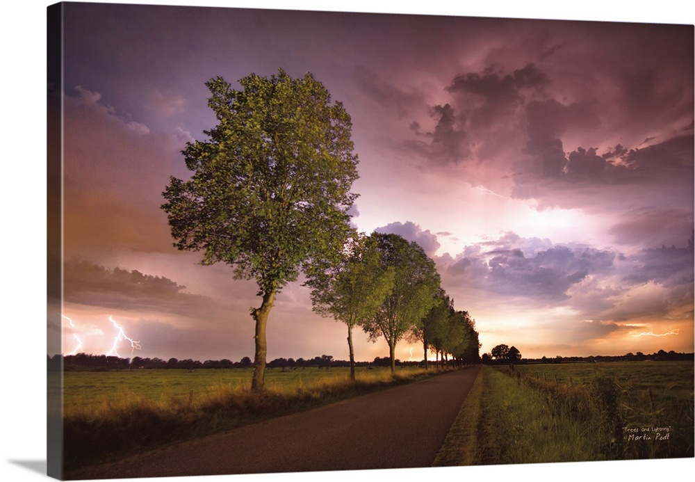 Lightning in the pink clouds over a tree-lined road in the countryside.