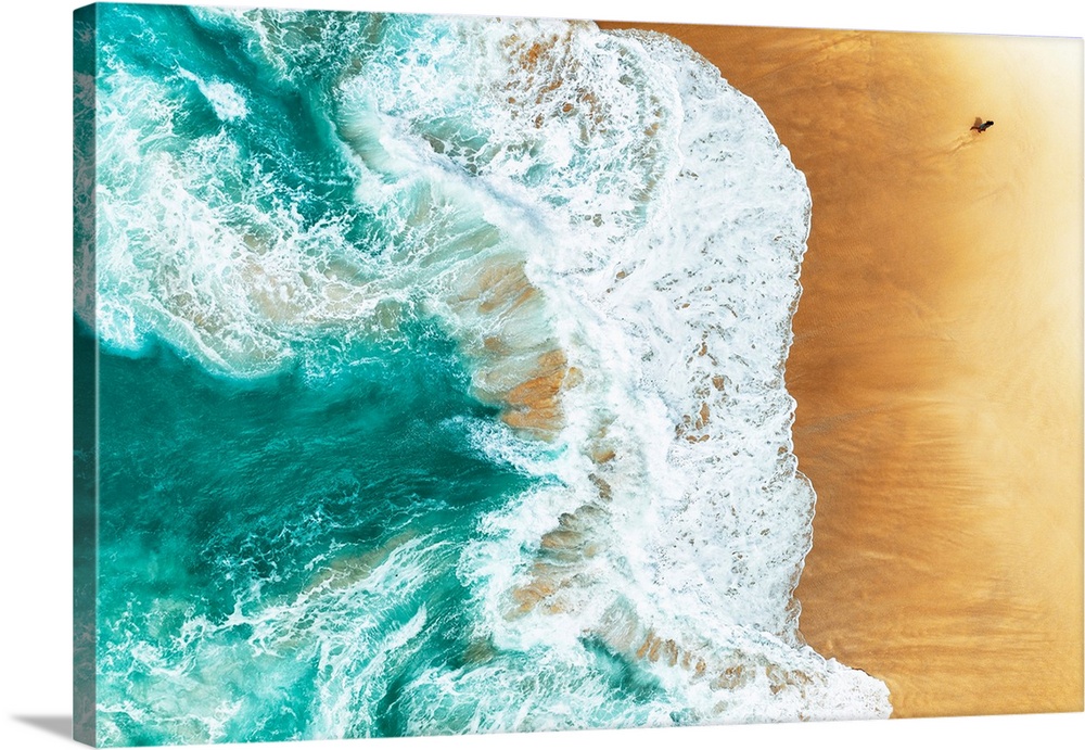 A stunning overhead aerial photograph of bright turquoise waves crashing onto a sandy beach
