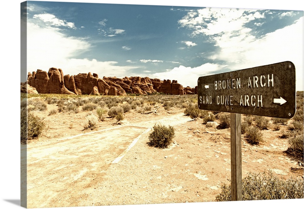 Signpost pointing towards Arches in opposite directions in the desert.