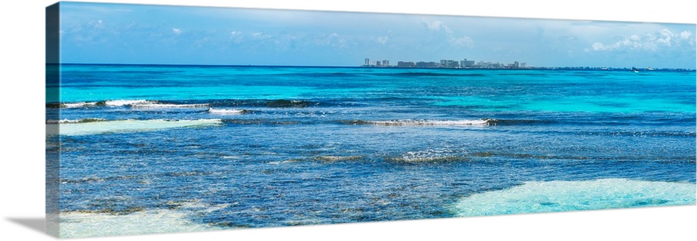 Panoramic photograph of the clear blue Caribbean ocean with the Cancun skyline in the background. From the Viva Mexico Pan...