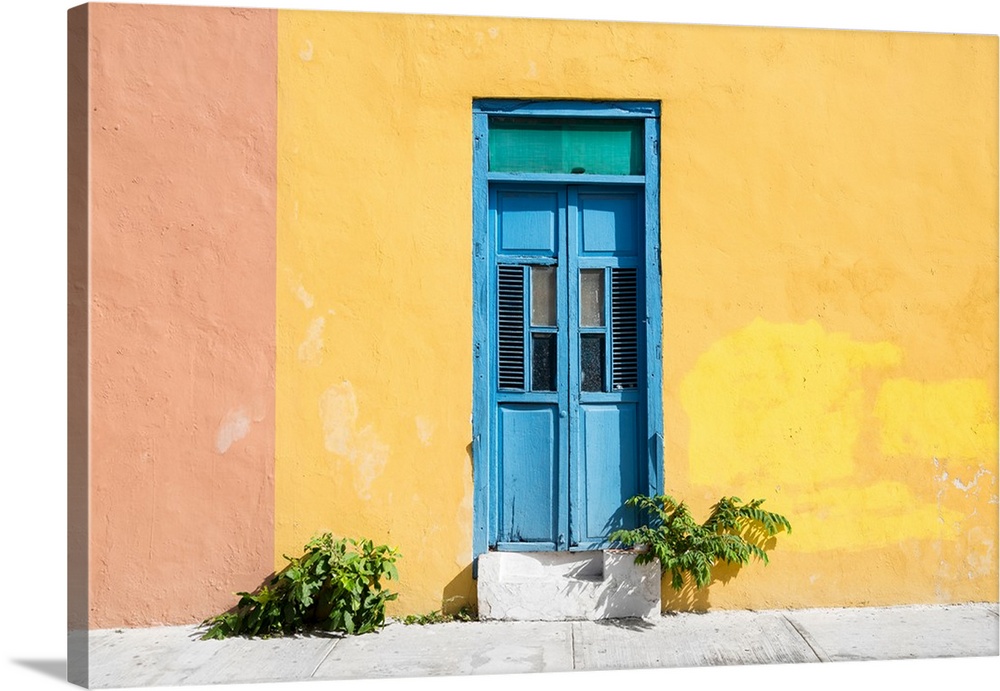 Photograph of a pale yellow and pink exterior wall with a bright blue door off the street in Mexico. From the Viva Mexico ...