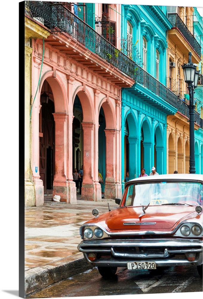Photograph of a red taxi parked on the wet streets of Havana with a colorful facade to the left.