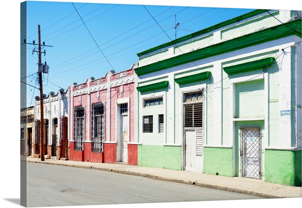 Photograph of a Havana streetscape with colorful facades lining the road.