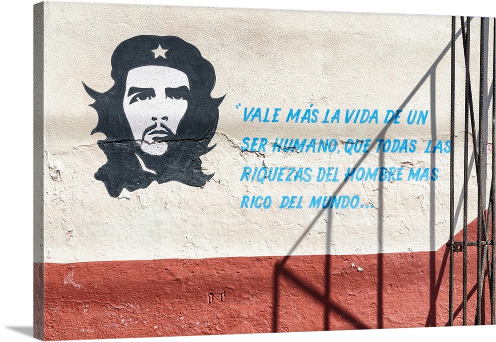 Wall graffiti of Che Guevara and a quote on a white and red wall in Havana.