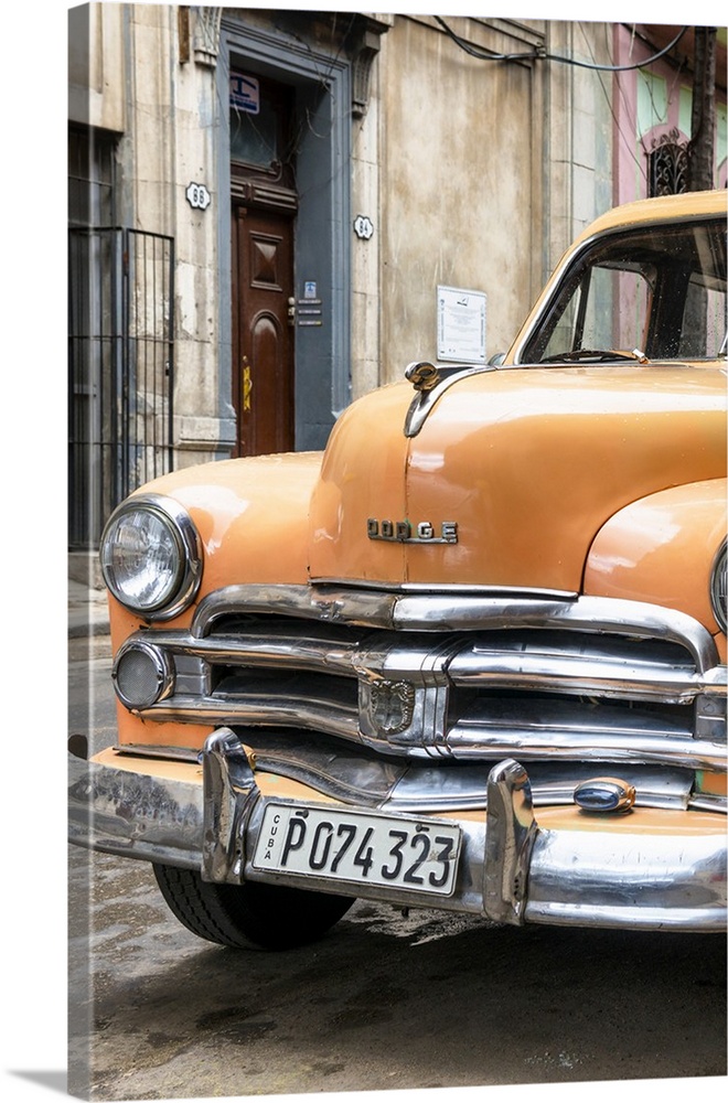 Photograph of the front of an orange vintage Dodge car parked in downtown Havana.