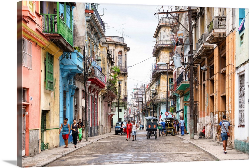 Photograph of a busy street scene in Havana, Cuba with colorful buildings lining the streets and people all over.