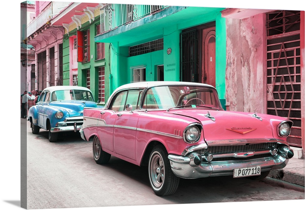 Photograph of a pink Chevrolet parked outside of brightly colored Cuban facades.