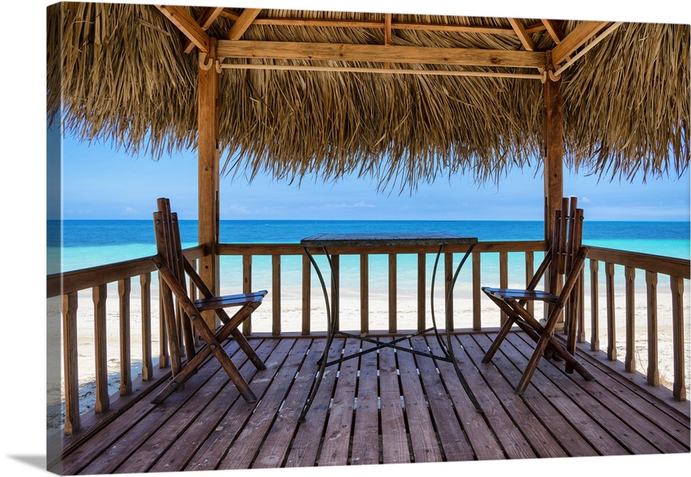 Photograph taken from inside a relaxing cabana on the beach with the crystal blue ocean in the distance.
