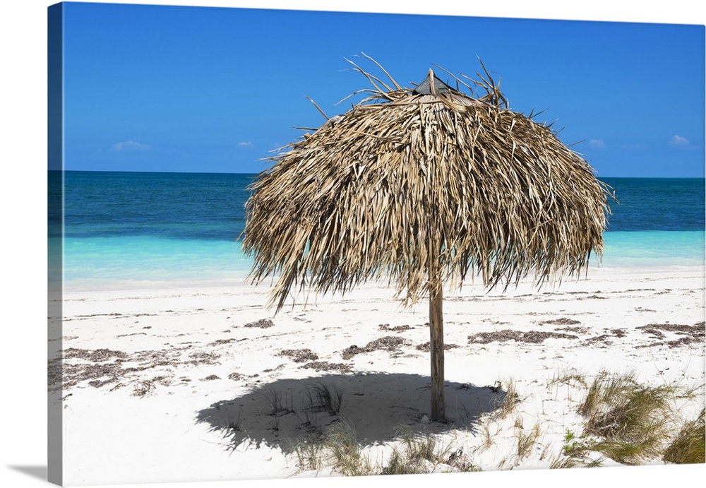 Photograph of an umbrella made with natural materials on a beautiful beach in Cuba.