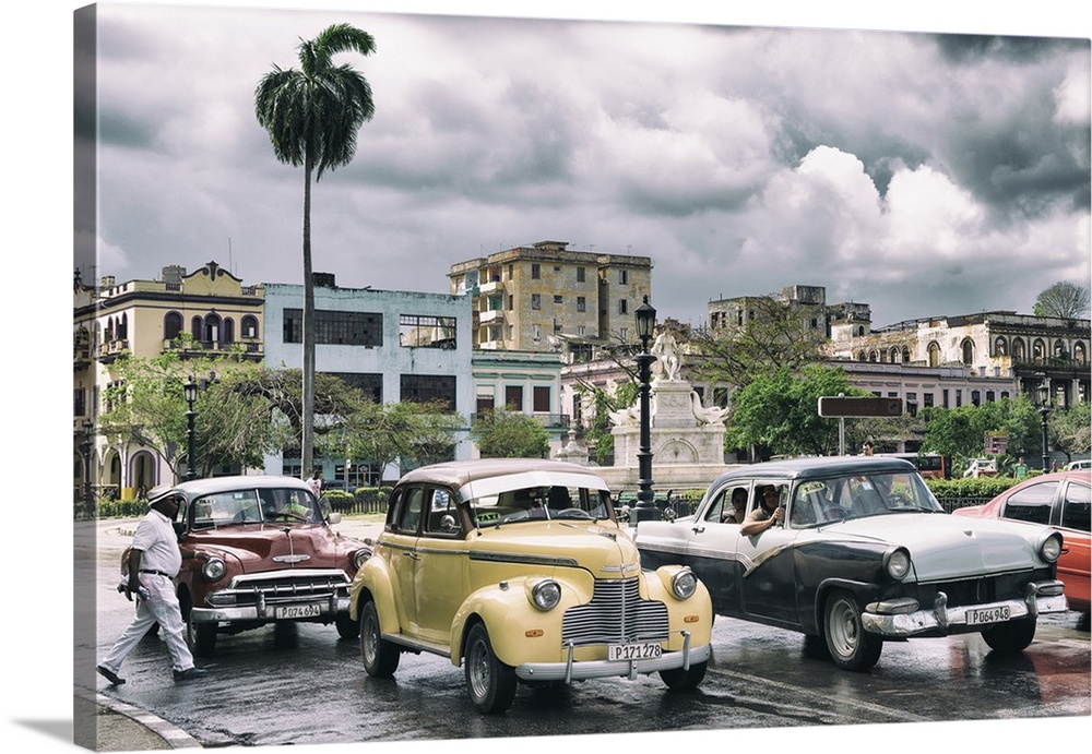 Photograph of dramatic rain clouds above a Havana street scene with vintage cars and taxis.
