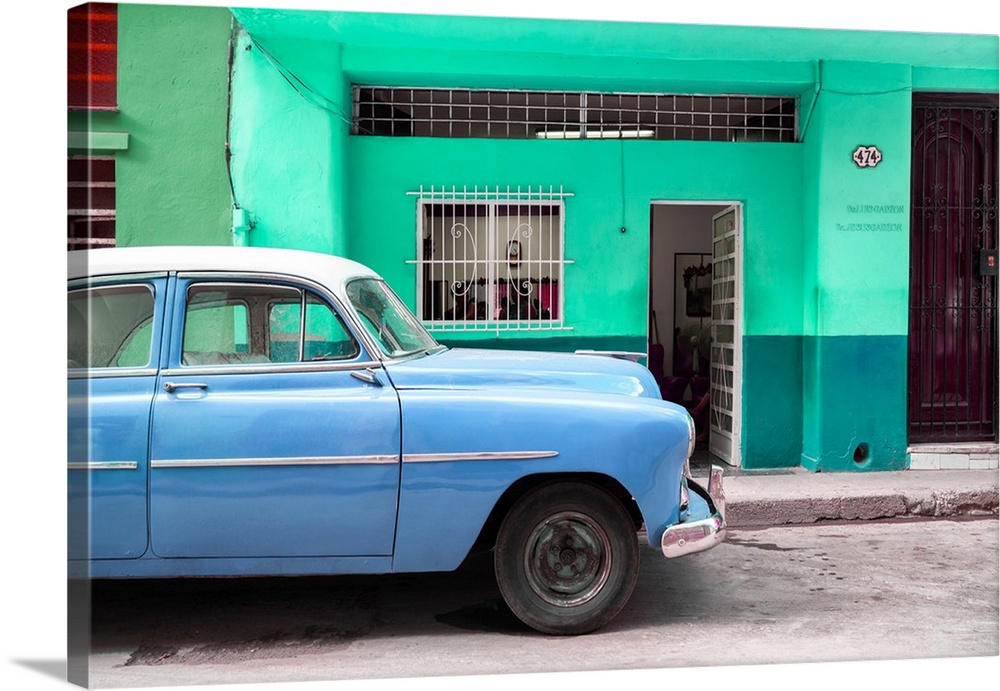 Photograph of a blue vintage car parked on the road in Havana.