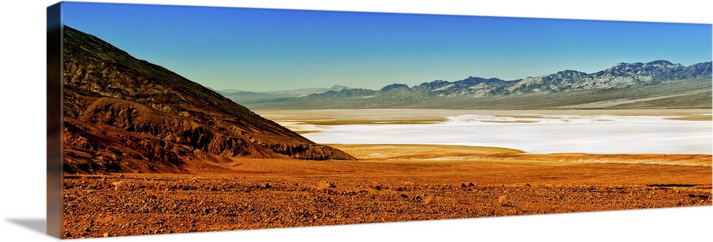 Photo of the Death Valley desert landscape, a flat plain bordered by low mountains.