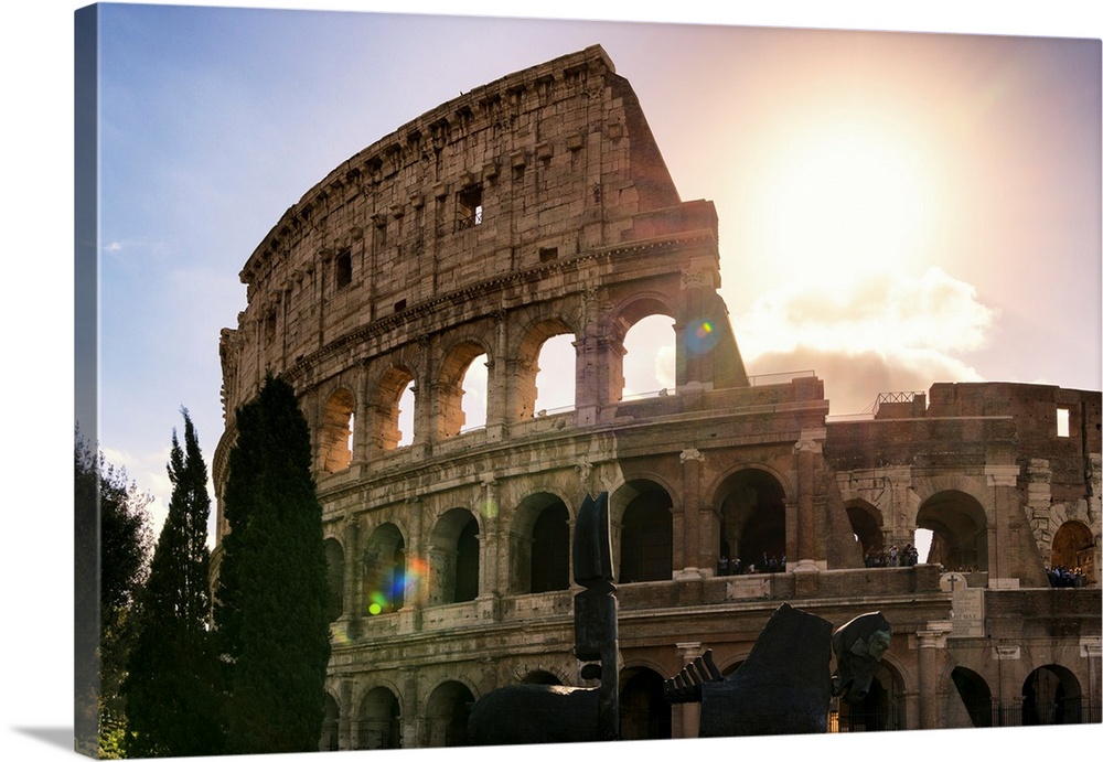 It's a view of the Colosseum at sunset in the centre of the city of Rome, Italy.