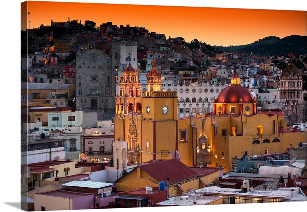 Photograph of a Guanajuato cityscape featuring the iconic Yellow Church at twilight under orange skies. From the Viva Mexi...