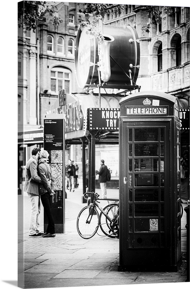 A couple in love being passionate beside an iconic London telephone booth.