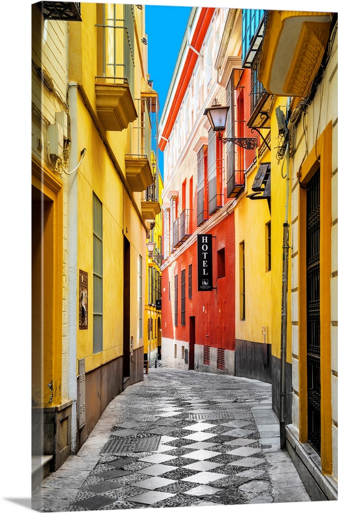 It's a traditional spanish street with colorful facades in the city of Seville in Spain.