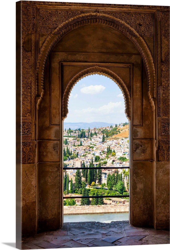 It's a view of the city of Granada by the ancient arches of the Alhambra, Spain.