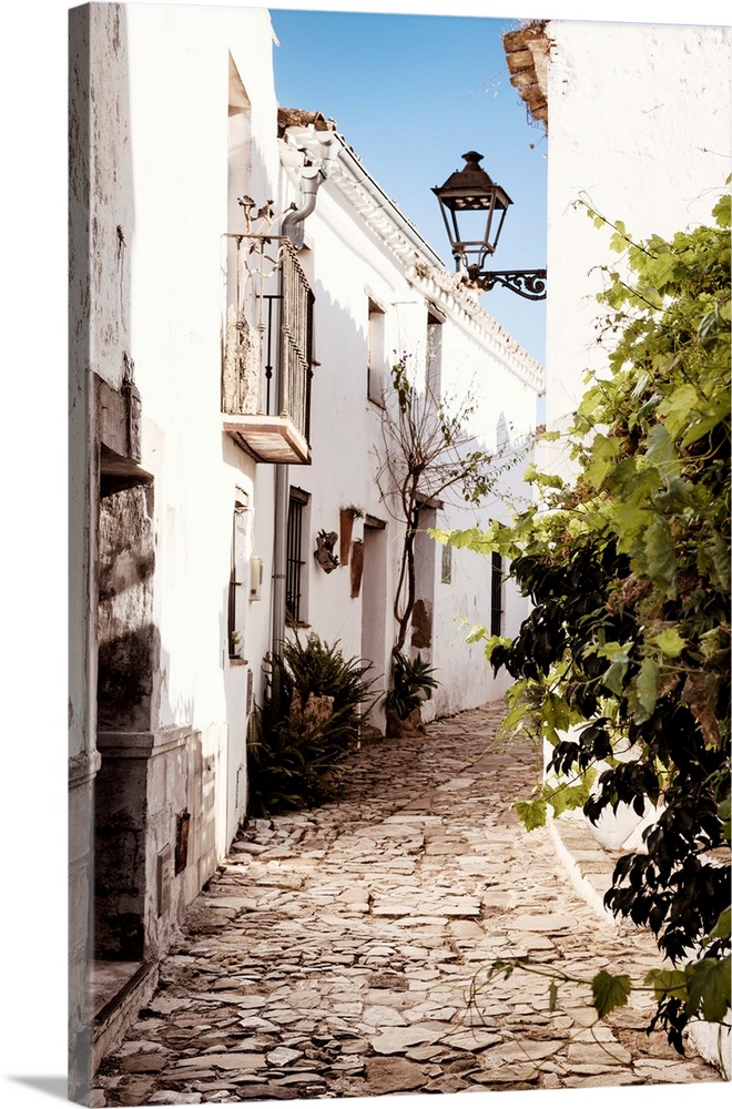 It's an old street with white buildings in the village of Castillo de Castellar in Spain.