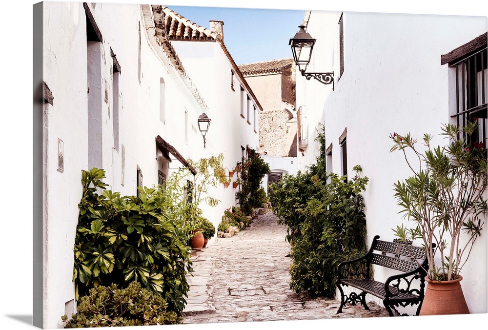 It's an old street with white buildings in the village of Castillo de Castellar in Spain.