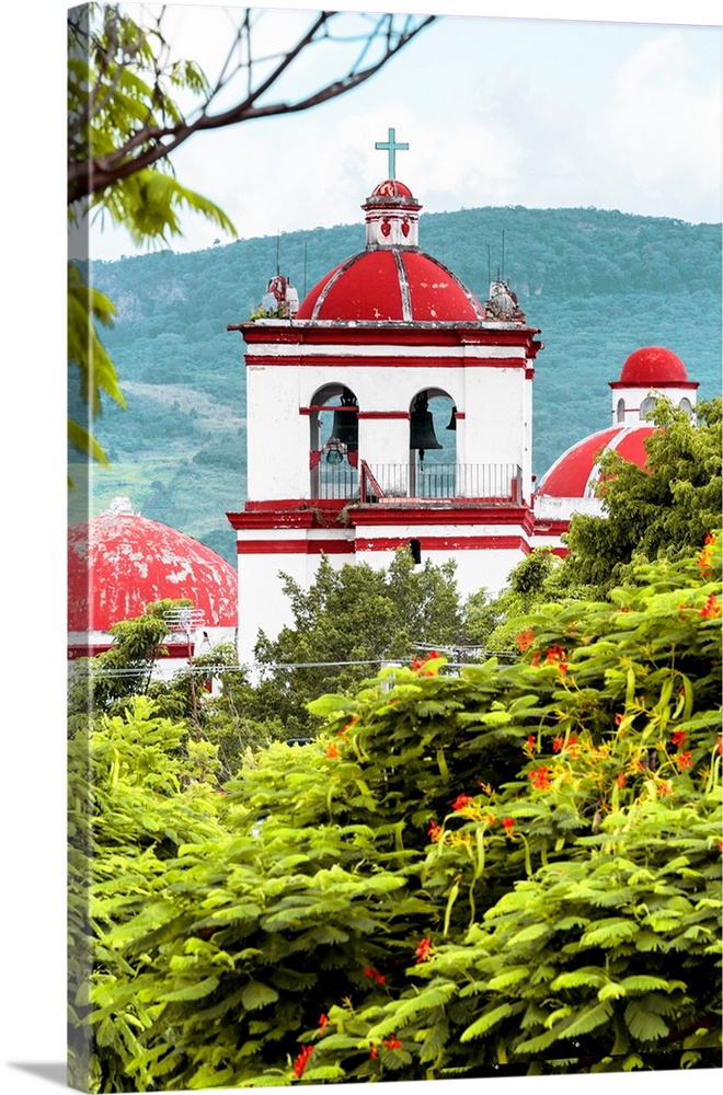Photograph of a red and white Church surrounded by lush trees and mountains. From the Viva Mexico Collection.