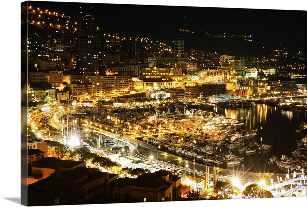 The city of Monaco filled with bright lights in the evening.