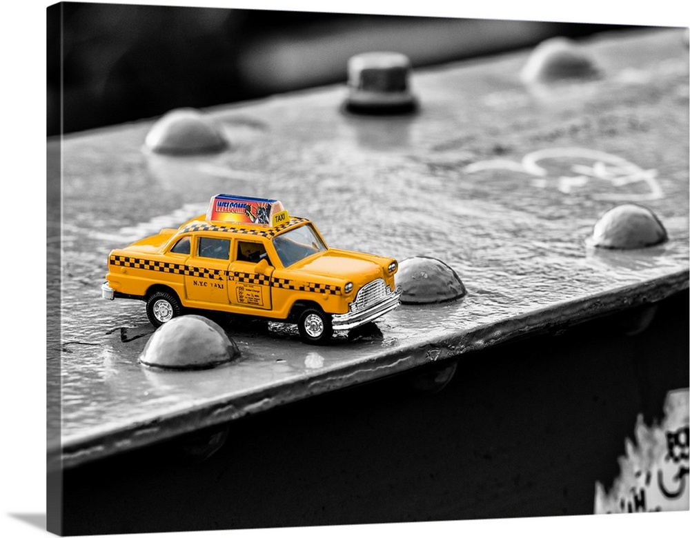 A photograph of a toy taxi cab sitting on a steel beam on the Brooklyn bridge.