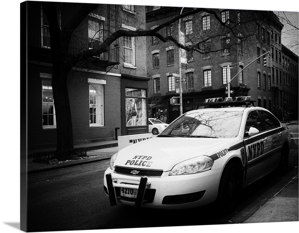 A black and white photograph of an NYPD police car in New York city.