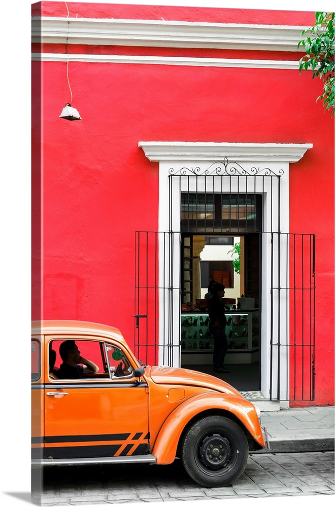 Photograph of a classic orange Volkswagen Beetle in front of a red building, Mexico. From the Viva Mexico Collection.