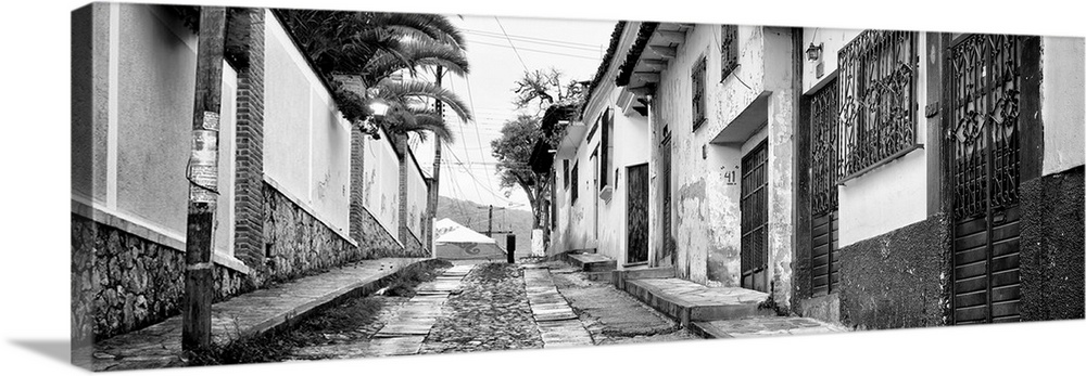 Black and white panoramic photograph of a streetscape at San Cristobal de Las Casas in Chiapas, Mexico. From the Viva Mexi...
