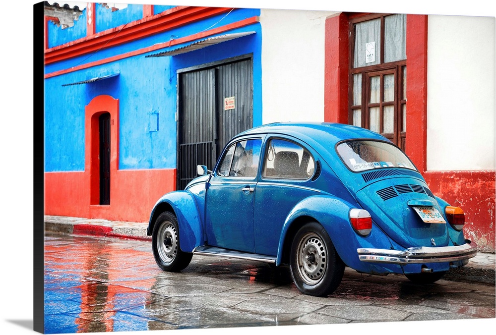 Photograph of a classic blue Volkswagen Beetle parked in front of a blue and red building. From the Viva Mexico Collection.