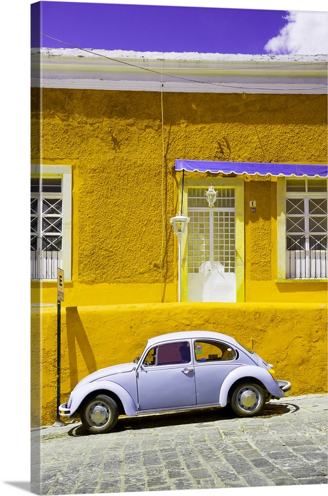 Photograph of a classic Volkswagen Beetle in front of a yellow and purple building. From the Viva Mexico Collection.