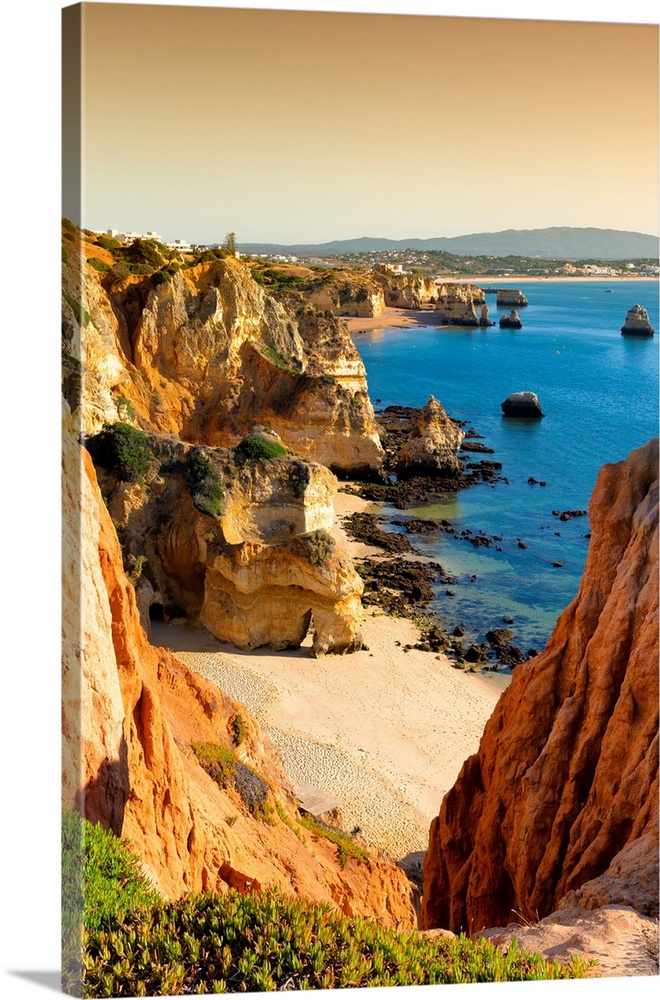 It's a view at sunset of Lagos beach (Praia do Camillo) and orange cliffs in Portugal.