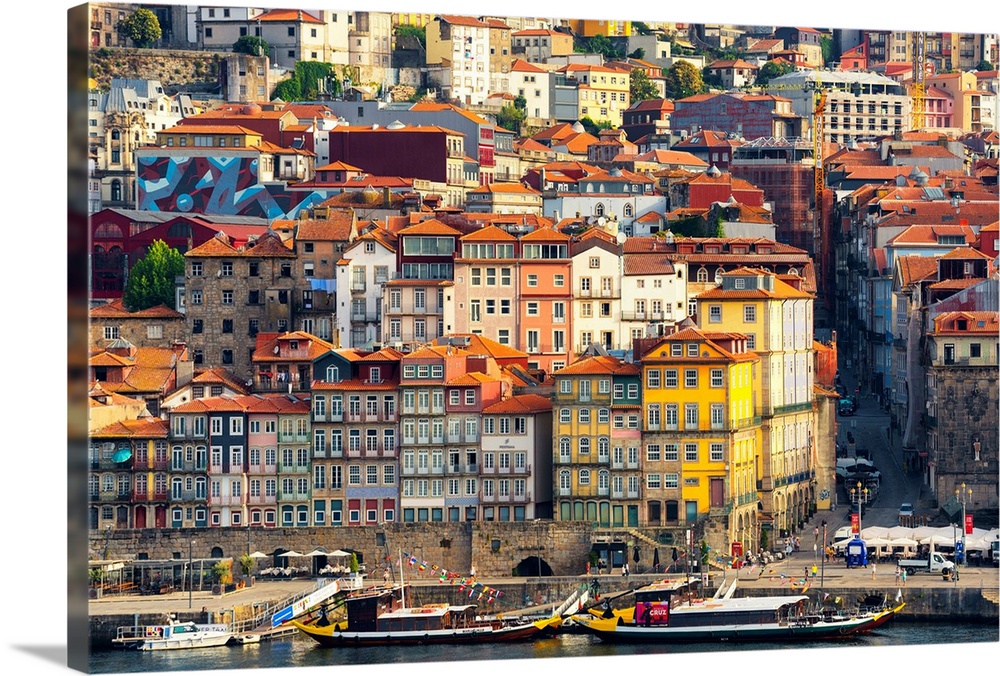 This is a view of the Ribeira district in Porto on the banks of the Douro river at sunset with the magnificent colorful fa...