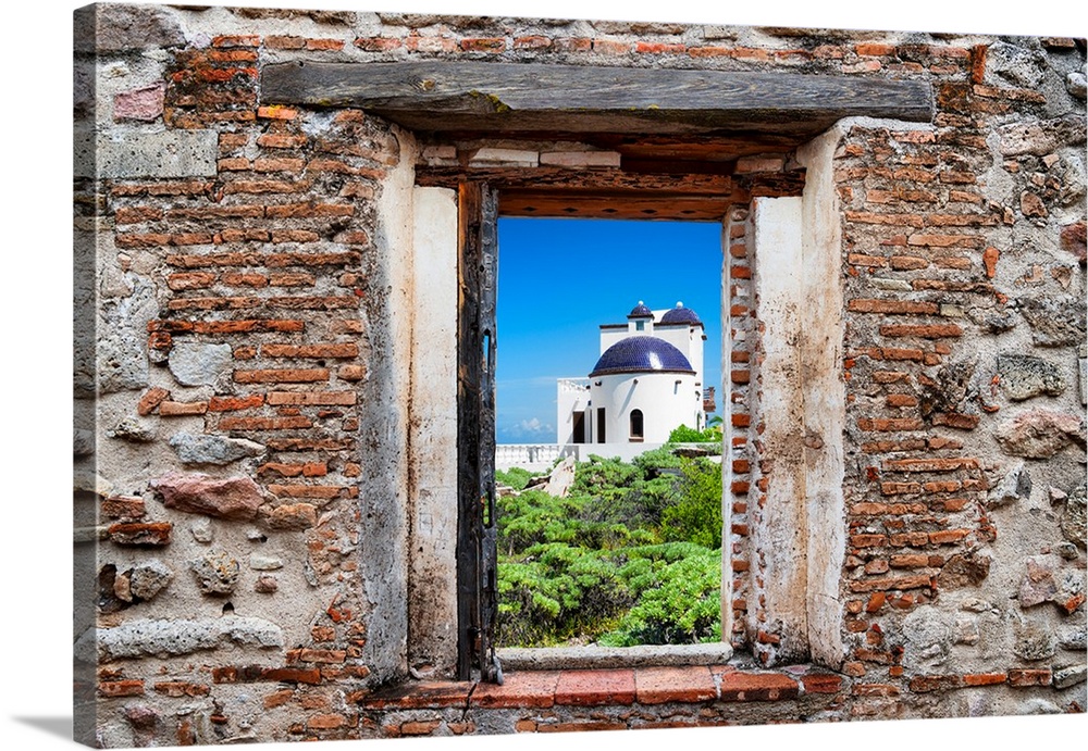 View of a white house in Isla Mujeres, Mexico, framed through a stony, brick window. From the Viva Mexico Window View.