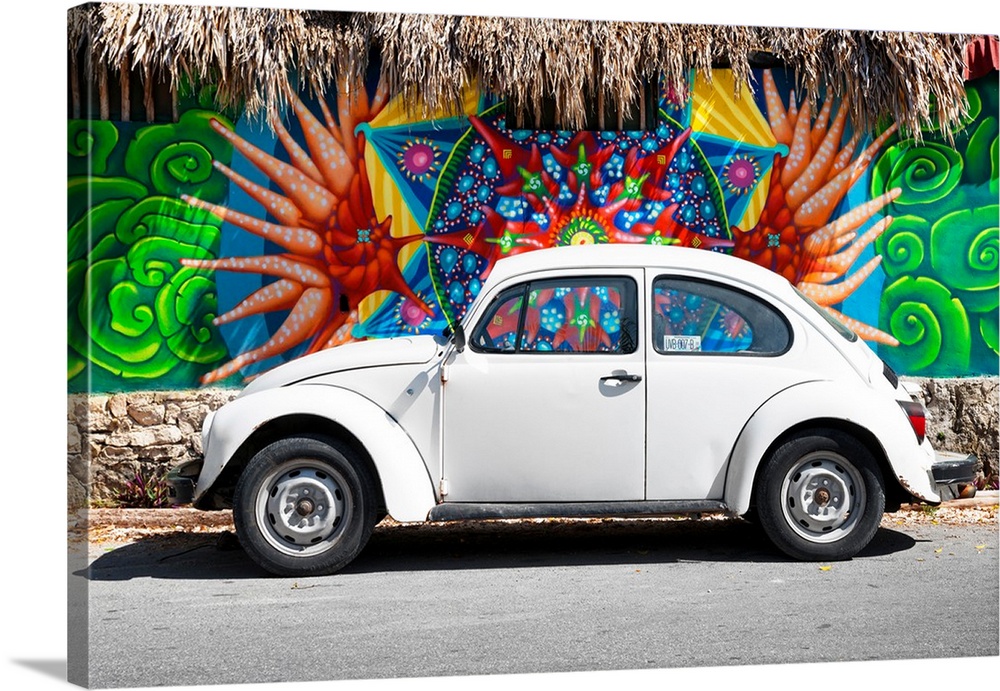 Photograph of a classic white Volkswagen Beetle parked in front of a wall covered in colorful graffiti in Cancun, Mexico. ...